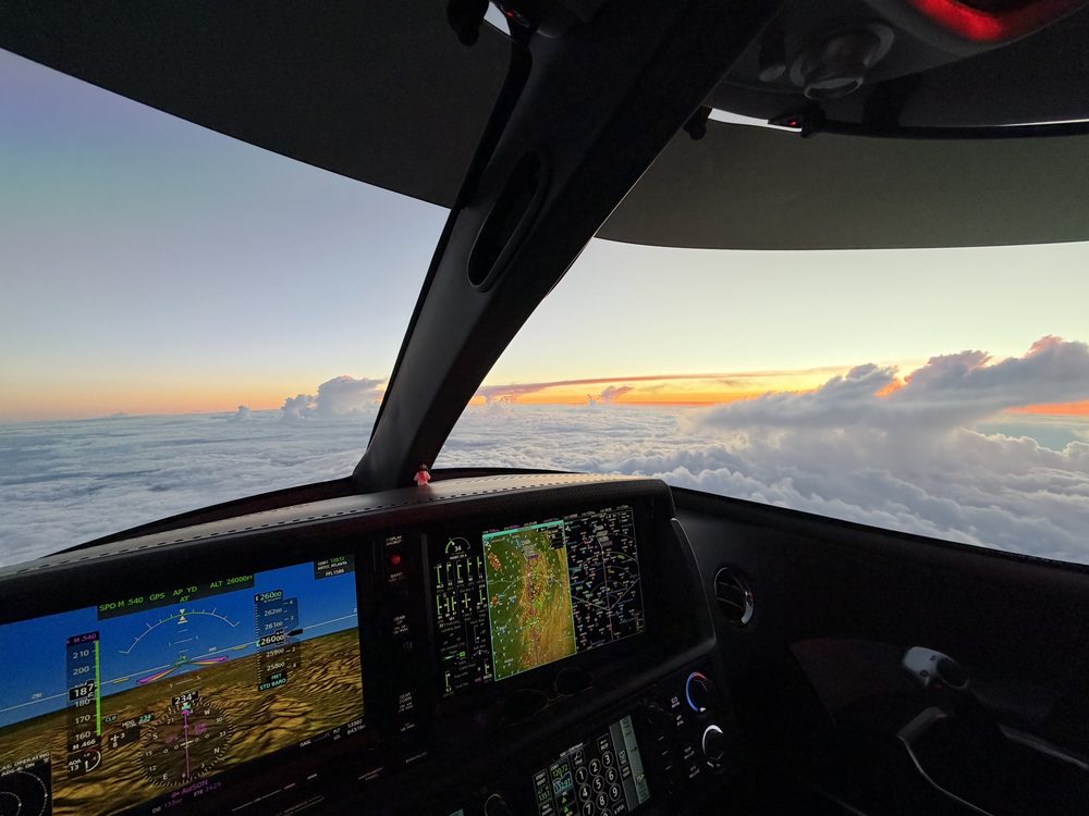 Vision Jet cockpit at sunset above the clouds
