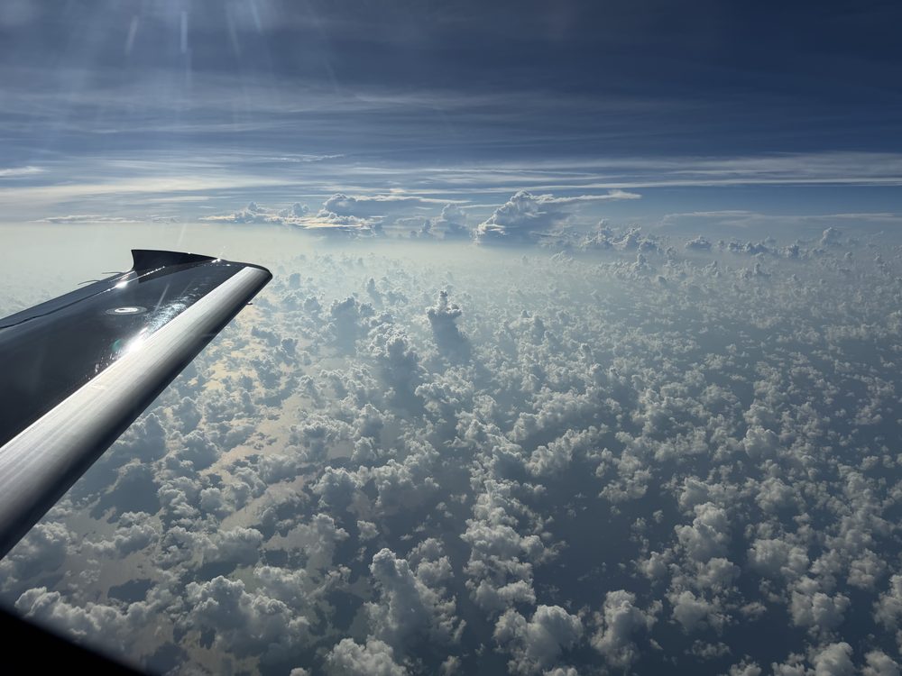 Vision Jet wing over cumulus clouds